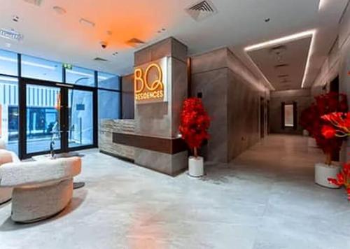 a large lobby with a bgas sign and red flowers at Luxury Hostel Bedspace in Downtown Near Emirates Towers Metro in Dubai