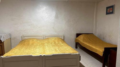 a bedroom with two beds with yellow sheets at tata's house in K'obulet'i