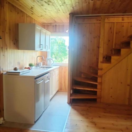 a kitchen with a sink and a staircase in a house at Sarni Zakątek in Rybno