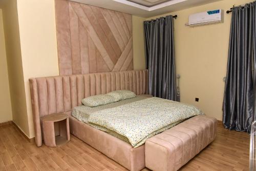 a bed with a large headboard in a room at 2 bedroom duplex apartment in Ibadan