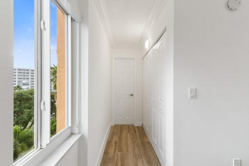 an empty hallway with white walls and windows at 2BR-2BA with Pool Gym Beach Marbella Tower in Sunny Isles Beach