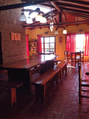 a dining room with a large wooden table and benches at El Alma De Yacanto Hotel Boutique in Villa Yacanto