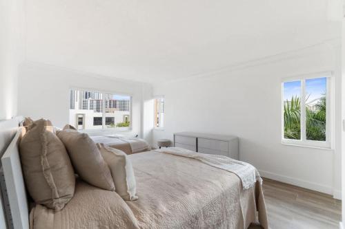a white bedroom with a bed and two windows at 2BR-2BA with Pool Gym Beach Marbella Tower in Sunny Isles Beach