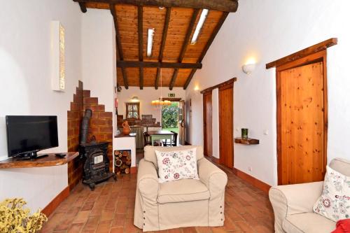 a living room with two chairs and a fireplace at Cerro Da Fontinha in São Teotónio