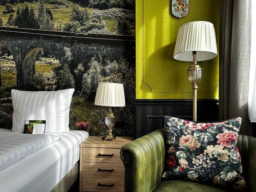 a bedroom with a bed and a chair and a lamp at Designhotel Central Fulda in Fulda