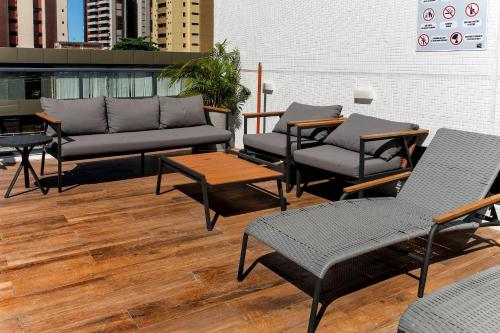 a patio with couches and chairs and a table at Simple Smart By Xtay - Novo, aconchegante e a 7min do Manaíra Shopping in João Pessoa