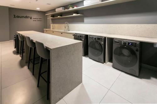 a laundry room with a counter and washing machines at Simple Smart By Xtay - Novo, aconchegante e a 7min do Manaíra Shopping in João Pessoa