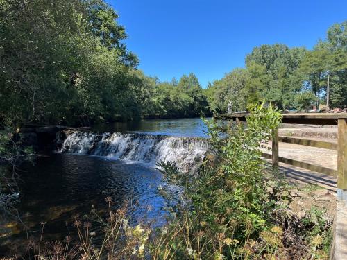 a waterfall on a river next to a bridge at A Casiña do Castiñeiro, Melide in Melide