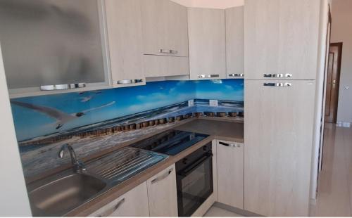 a kitchen with white cabinets and a sink at Apartament Gabbiano Bianco in Torretta