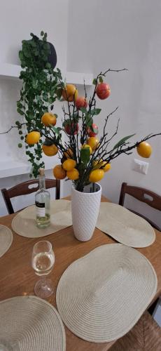 a wooden table with a vase with oranges on it at Apartament Gabbiano Bianco in Torretta