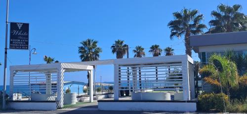 a pavilion with palm trees in front of a building at Apartament Gabbiano Bianco in Torretta