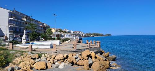 a dock with rocks in the water next to a building at Apartament Gabbiano Bianco in Torretta
