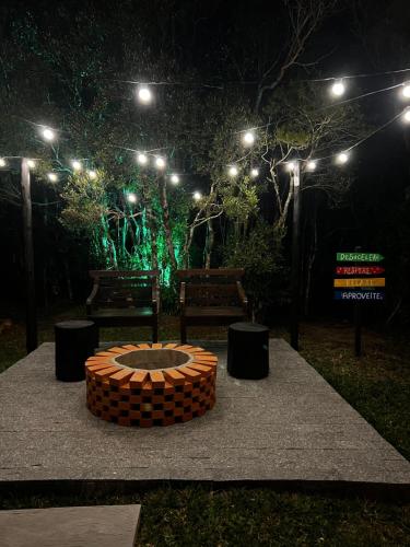 a garden at night with a bench and lights at Chalé Heinz in Rancho Queimado