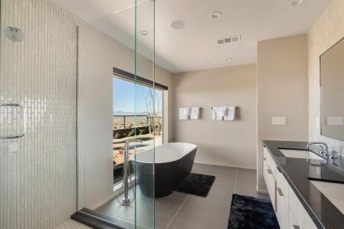 a bathroom with a glass shower and a black tub at Addendum Estate - 2 Pools, Panoramic Views & Luxe Privacy for Groups in Desert Hot Springs