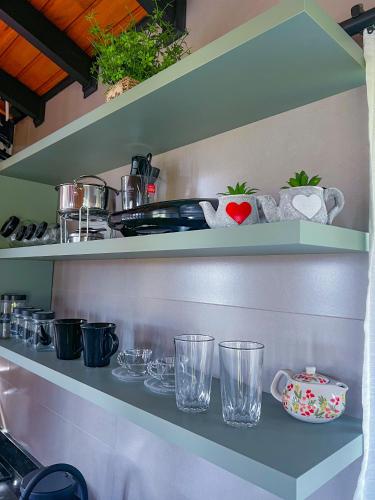a shelf with glasses and other items on it at Chalé Heinz in Rancho Queimado