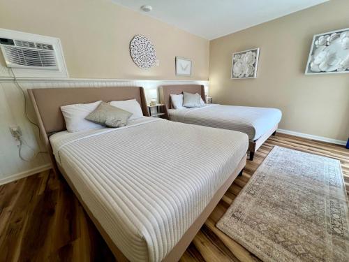 two beds in a small room with a rug at Green Acre Motel in Lake George