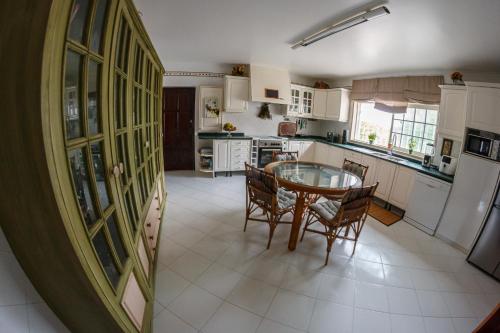 a kitchen with a table and chairs in it at Casa do Marmeleiro Guest House in Alcabideche