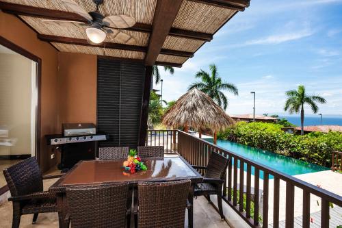 a balcony with a table and chairs and a pool at Rooftop Pool & Ocean Views, Sunset BBQ in Ocotal