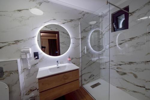 a bathroom with a sink and a mirror at Pensiune Restaurant PERLA in Ciucea