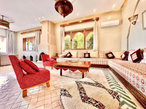 een woonkamer met een bank, stoelen en een tafel bij Chanel in Marrakesh