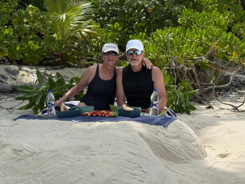 two people sitting at a table on the beach at Suncoral Maldives in Kondey