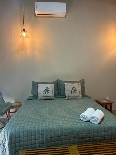 a bedroom with a green bed with two towels on it at Terra Verde Visconde de Mauá in Visconde De Maua