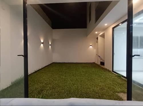 an empty room with a large room with green grass at Friendly house in Huanchaco