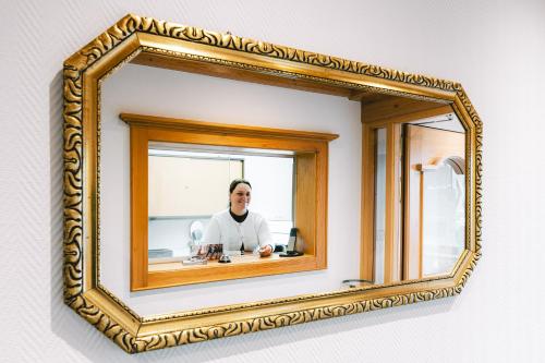 a mirror in a gold frame on a wall at Heiterwanger Hof Appartments in Heiterwang