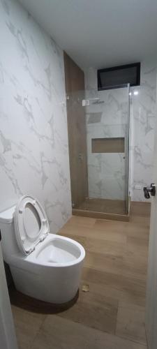a bathroom with a toilet with the seat up at Friendly house in Huanchaco