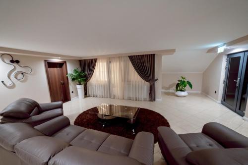 a living room with a couch and a glass table at Pensiune Restaurant PERLA in Ciucea