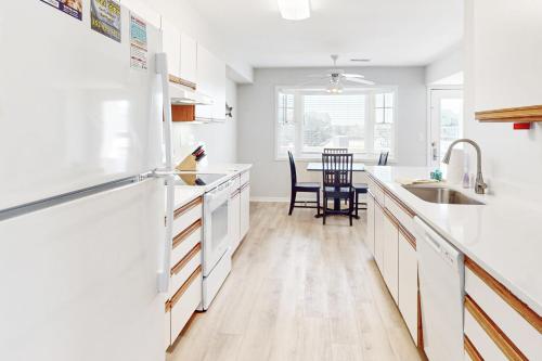 a kitchen with white appliances and a table with chairs at Yellowfin in Buxton