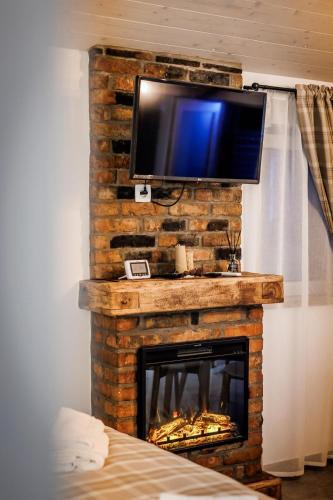 a fireplace with a television on top of it at D&D Bucovina in Câmpulung Moldovenesc