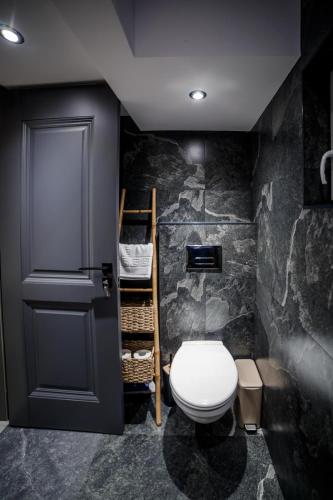 a bathroom with a white toilet and a door at D&D Bucovina in Câmpulung Moldovenesc