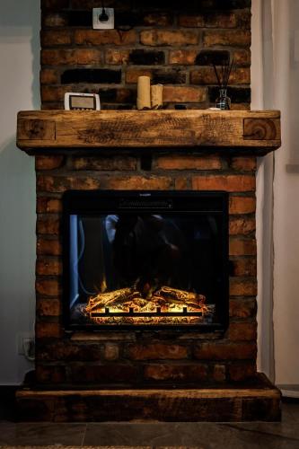 a brick fireplace with a fire in it at D&D Bucovina in Câmpulung Moldovenesc