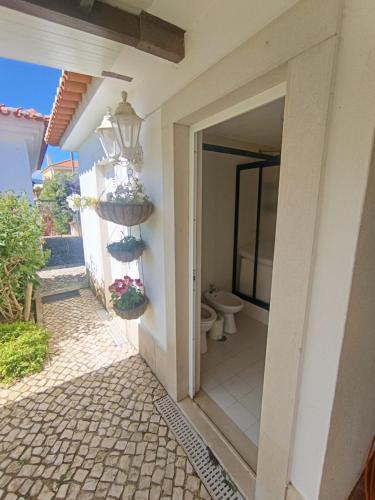 a door leading to a bathroom with a toilet at Casa do Marmeleiro Guest House Cascais in Cascais