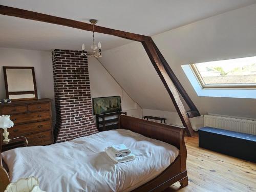 a bedroom with a bed in a attic at Les Roses du Souvenir in Mailly-Maillet