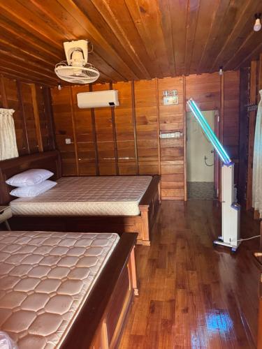 a room with two beds in a wooden cabin at Luna bungalow chi phat in Chi Phat