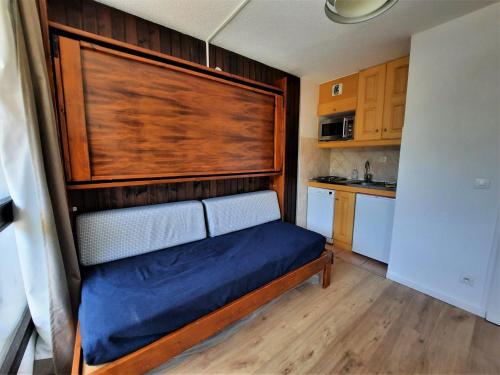 une petite chambre avec un lit et une tête de lit en bois dans l'établissement Studio 3 personnes avec balcon aux Menuires, ski aux pieds - FR-1-452-50, aux Menuires