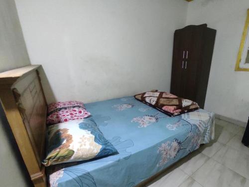 a small bedroom with a bed with a blue comforter at Giza Pyramids Hotel in Cairo
