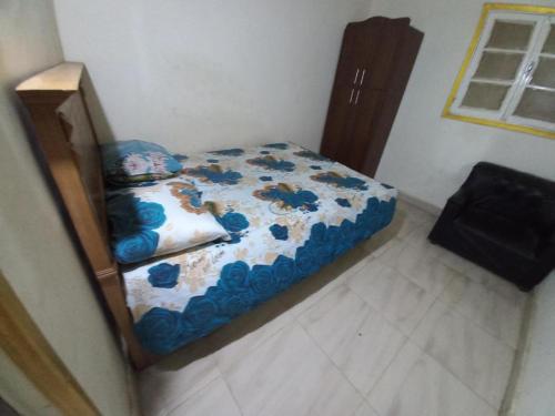 a small bed with a blue and white comforter in a room at Giza Pyramids Hotel in Cairo