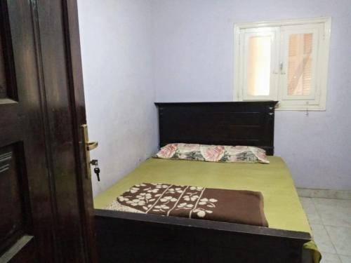 a small bedroom with a bed and a window at Giza Pyramids Hotel in Cairo