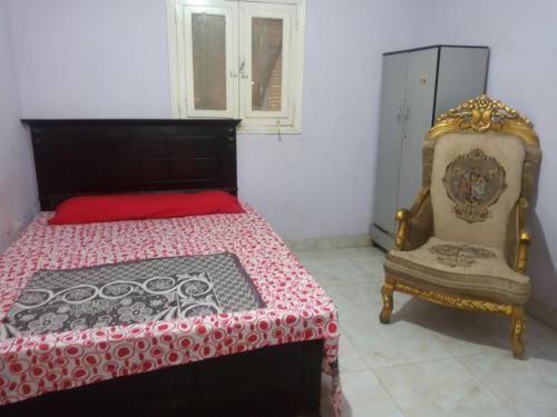 a bedroom with a bed and a chair at Giza Pyramids Hotel in Cairo