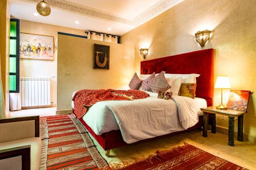 a bedroom with a large bed with a red headboard at Riad Atrium & Spa in Marrakech