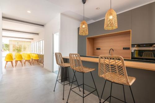 a kitchen with chairs and a bar with a counter at Sercotel El Balcón de la Bahía Suites in Santander