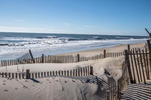 a wooden fence on a beach with the ocean at Southern Comfort Cabana #25ODC-H in Hatteras