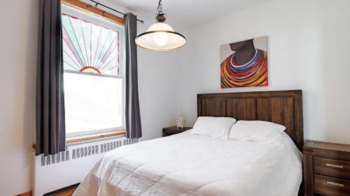 une chambre avec un lit blanc et une fenêtre dans l'établissement Downtown Heritage House and Free Parking, à Joliette