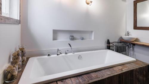 La salle de bains est pourvue d'une grande baignoire blanche. dans l'établissement Downtown Heritage House and Free Parking, à Joliette