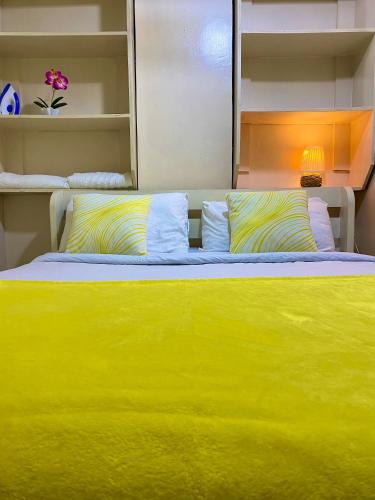 a yellow bed with pillows in a bedroom at Opal suites KE - South B in Nairobi