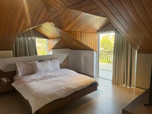 una camera da letto con un letto grande con soffitto in legno di Terminal K Bhamdoun Hotel a Aley