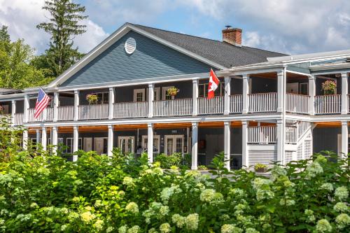 a large white house with two american flags at The Shire Woodstock in Woodstock